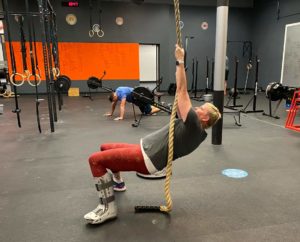 CPM member, Crash, doing a rope climb in the gym